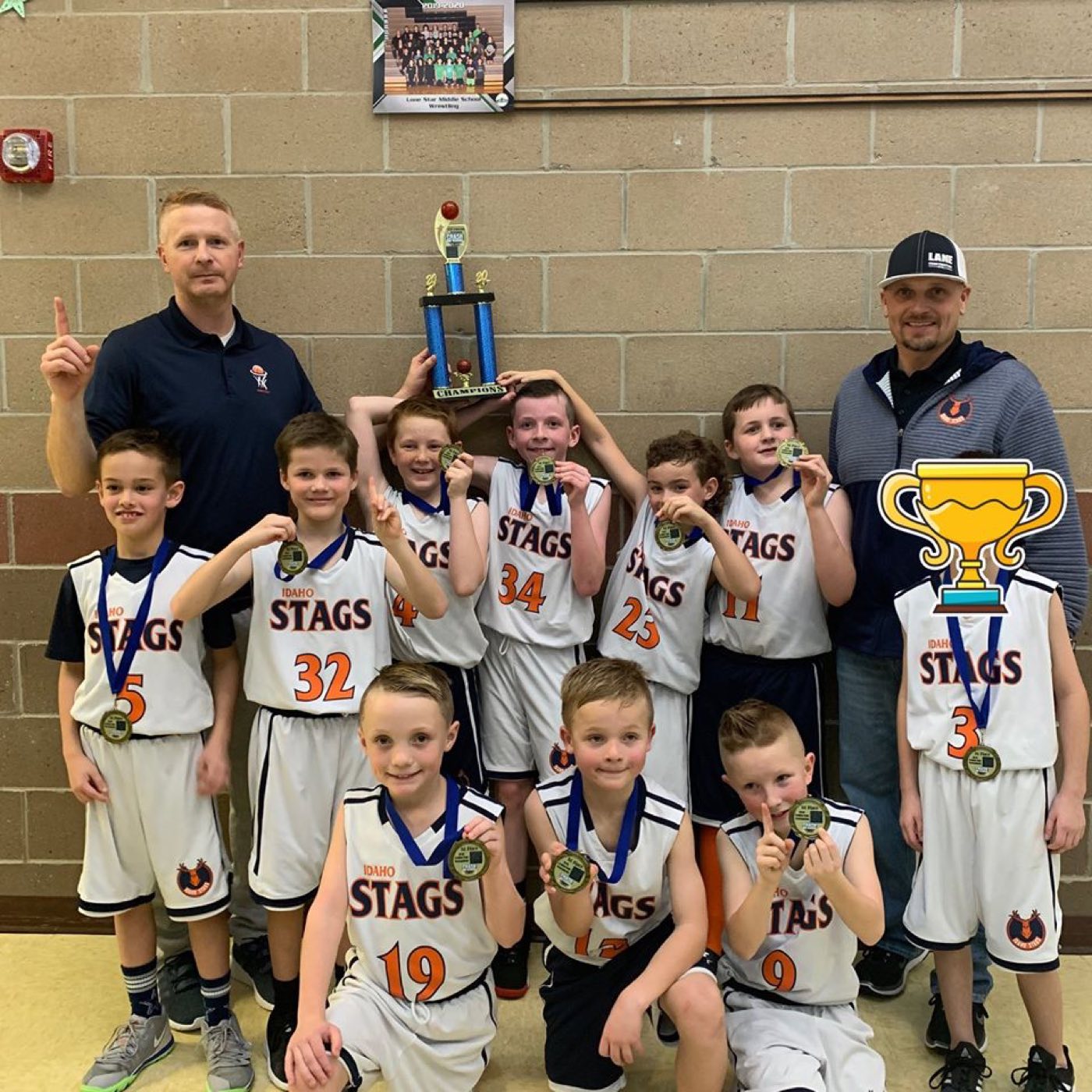Idaho Stags team celebrates a tournament championship with a trophy and medals