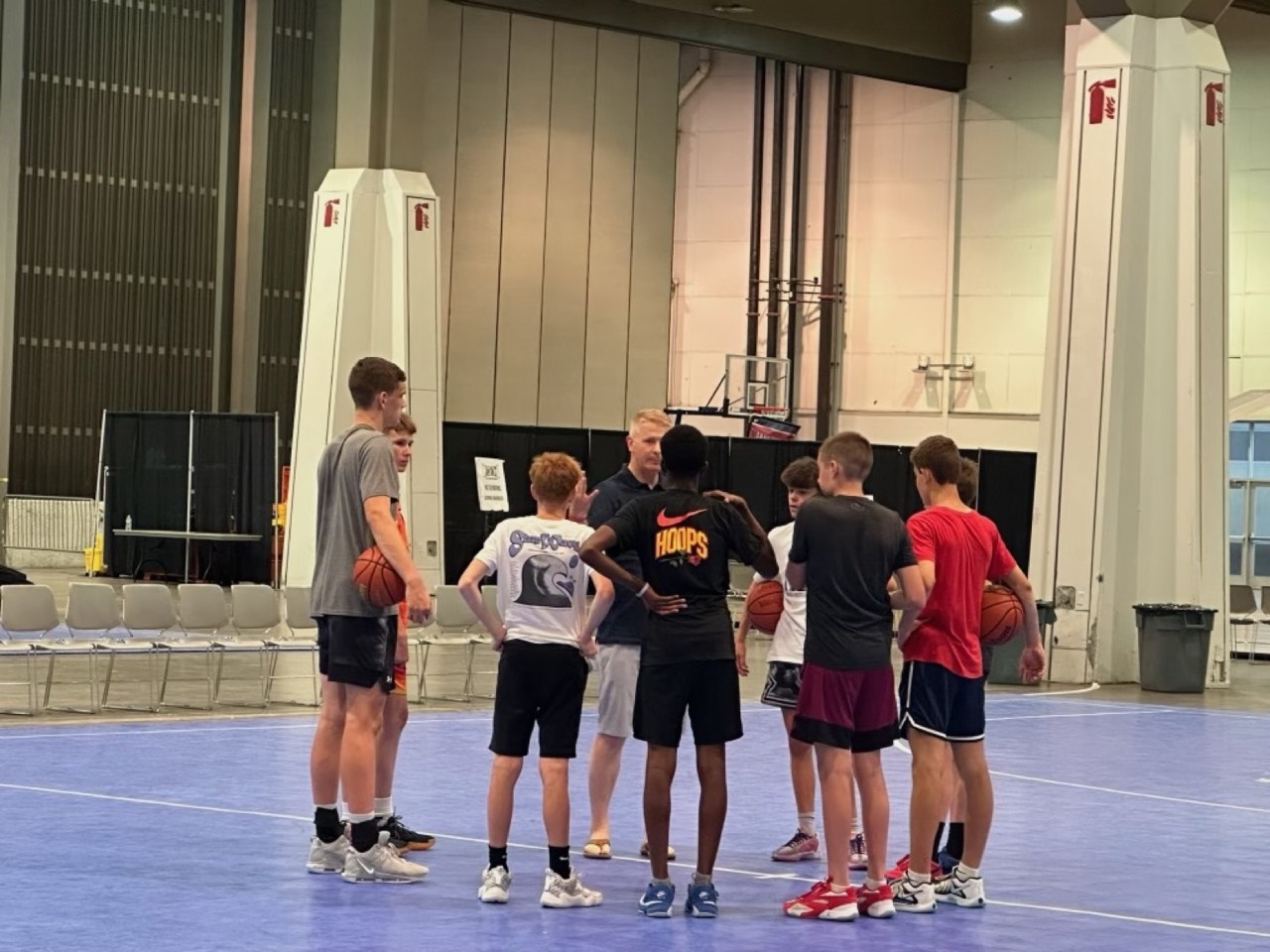 Idaho Stags players huddle around their coach at a training session